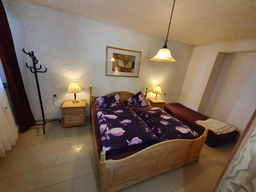 a bedroom with a bed with purple comforter at Hotel Jungmann in Saarlouis