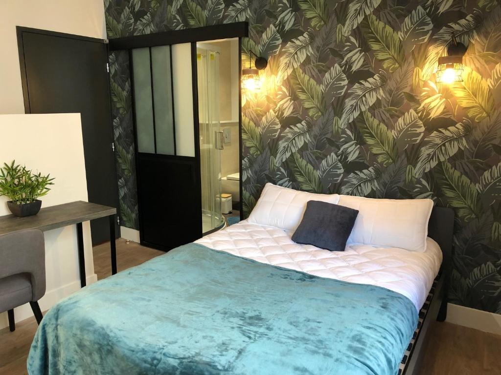 um quarto com uma cama com papel de parede tropical em DUPLEX COSY HYPER CENTRE CHOLET em Cholet