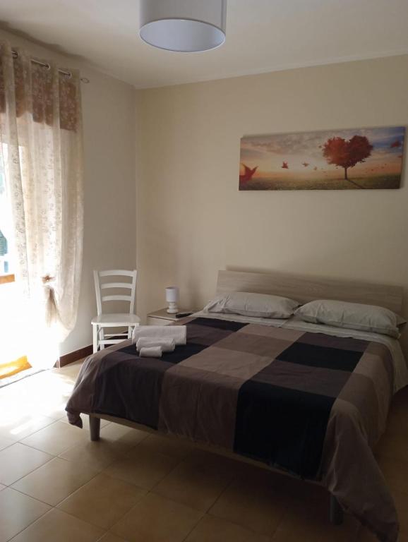 a bedroom with a large bed and a chair at B&B La Maison in Canicattì