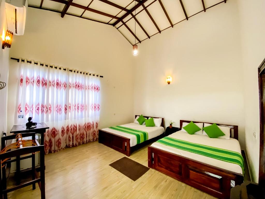 1 dormitorio con 2 camas y ventana en Lavender Home Yala Safari en Tissamaharama