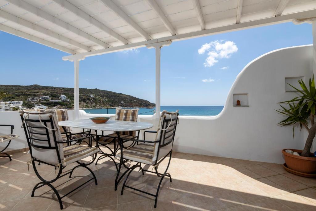 a patio with a table and chairs and the ocean at Pension Moschoula in Platis Gialos