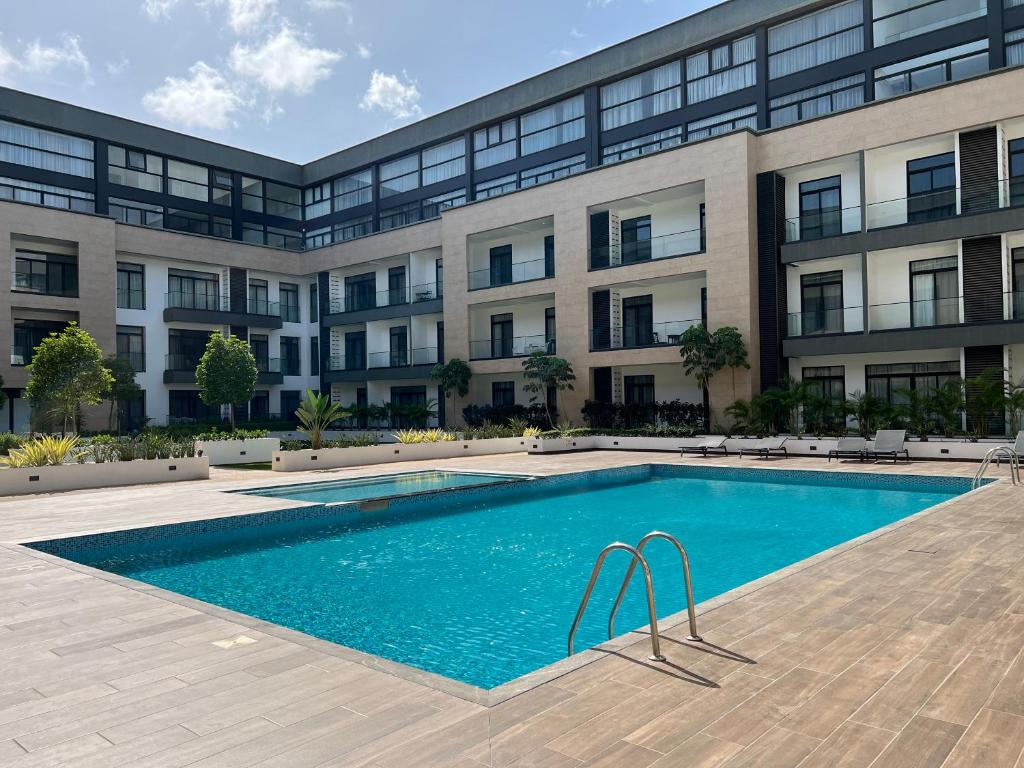 アクラにあるEmbassy Gardensの建物の前のプール