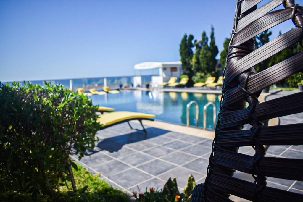 a wooden bench sitting next to a swimming pool at Auberge Oualidia Dream in Oualidia