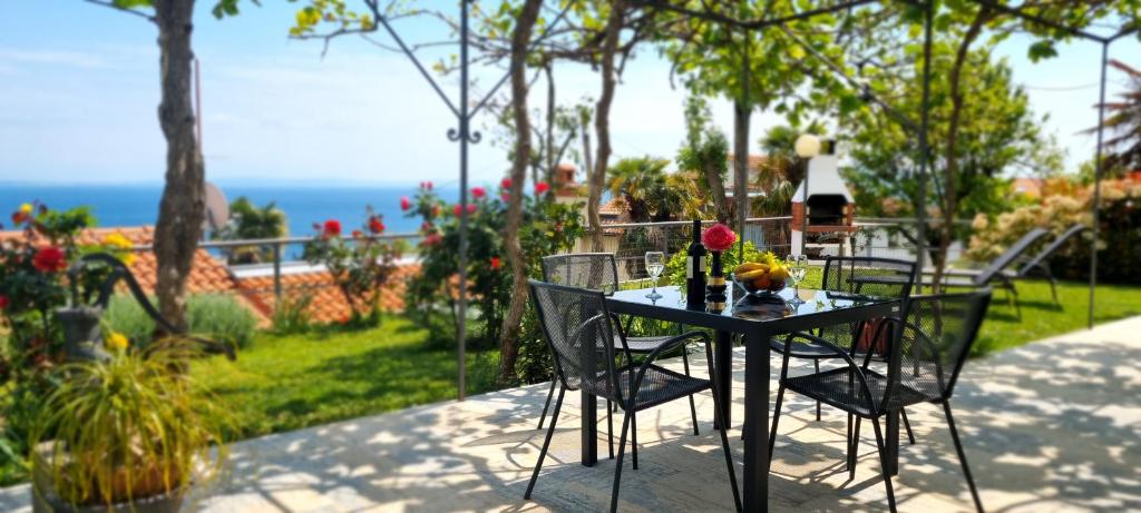 a black table and chairs with a view of the ocean at Apartments Anamarija in Opatija