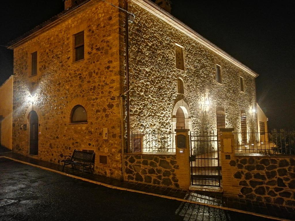 un edificio in pietra con luci accese di notte di Podere del Papa a Viceno