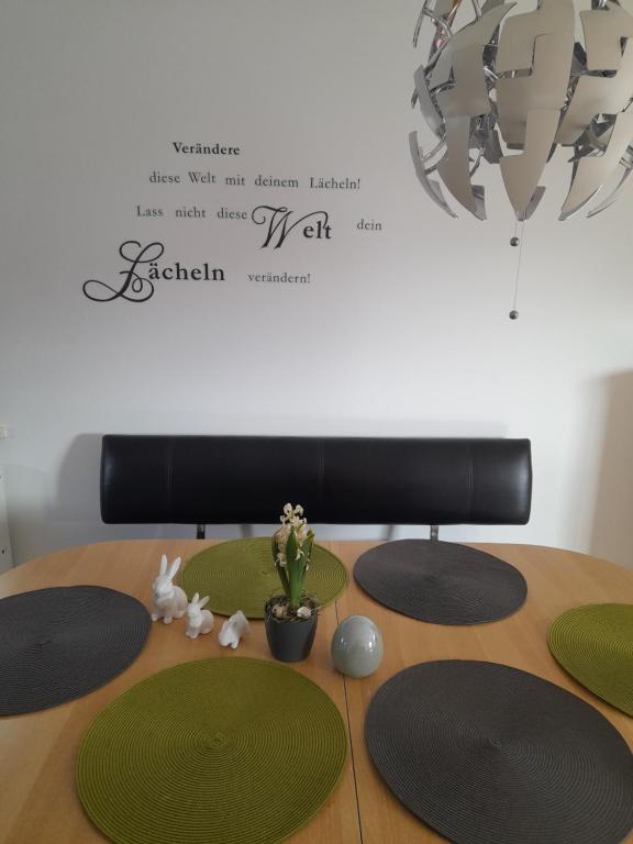 einem Tisch mit grünen Platten und einer Topfpflanze darauf in der Unterkunft Sonnenparkhaus in Roth