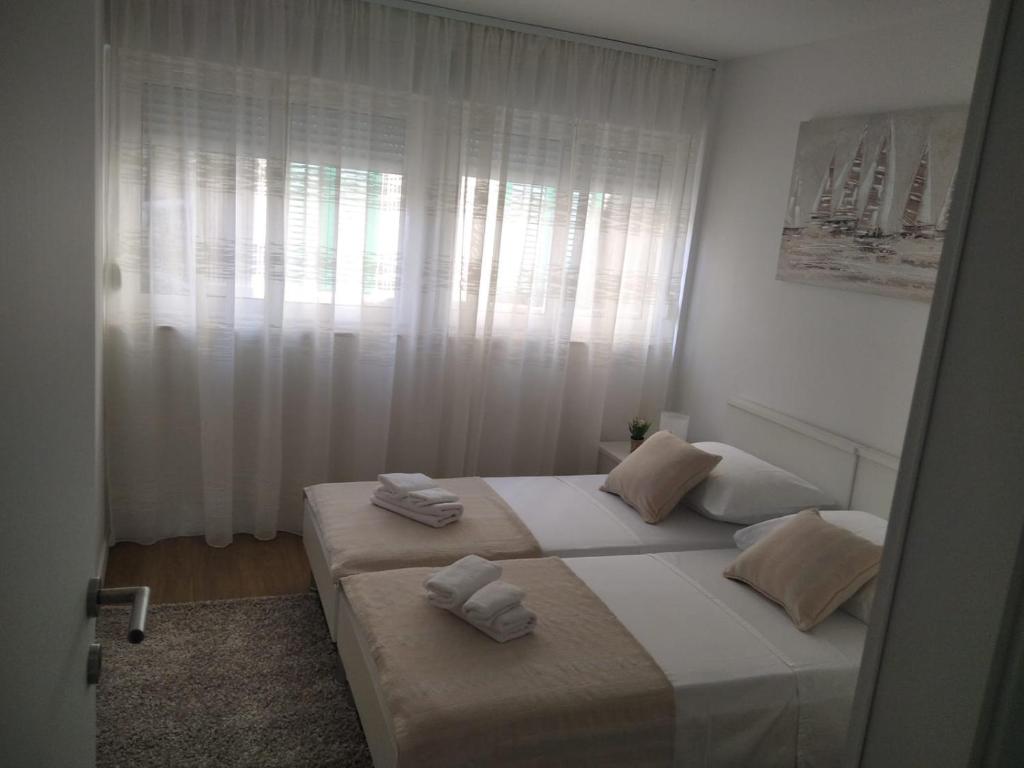 una camera da letto con due letti con asciugamani sopra di Apartment Mateo a Spalato (Split)