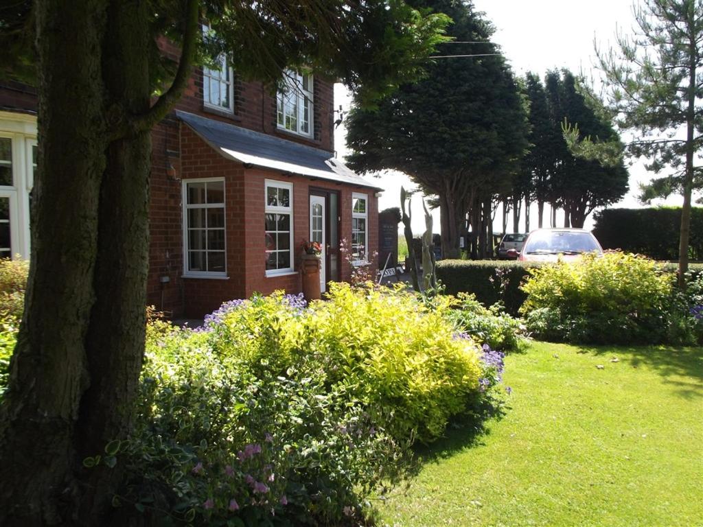 a red brick house with flowers in the yard at Woldview House Bed and Breakfast in Tealby