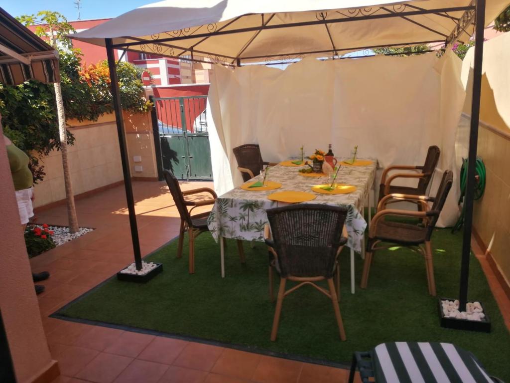 アロナにあるCamelotの芝生の上の傘下のテーブルと椅子