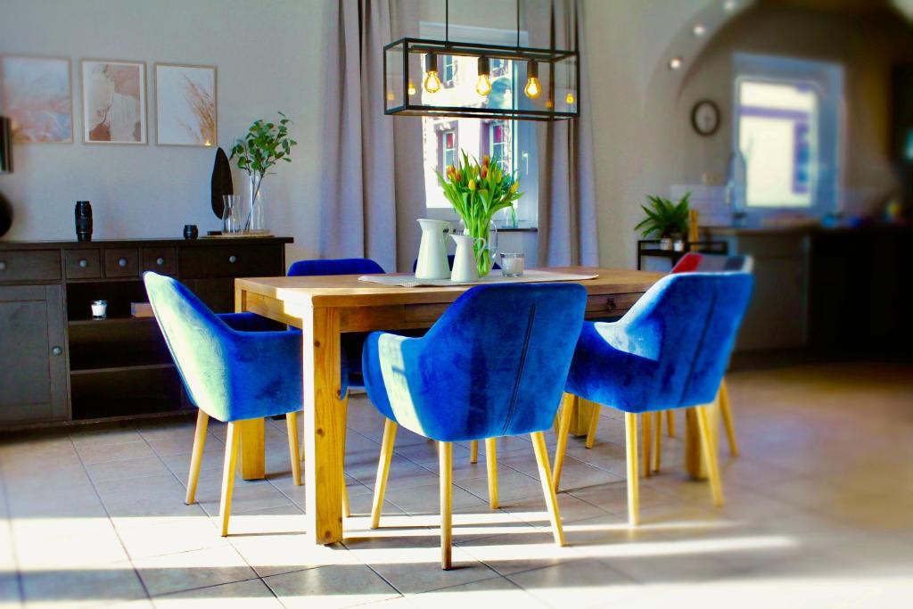 una mesa de comedor con sillas azules alrededor en Ferienhaus CLARNI, en Sankt Wendel