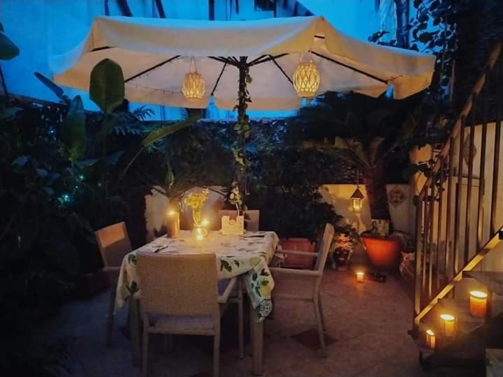 stół ze świecami i parasolem na patio w obiekcie Casa Sicana w mieście Palermo
