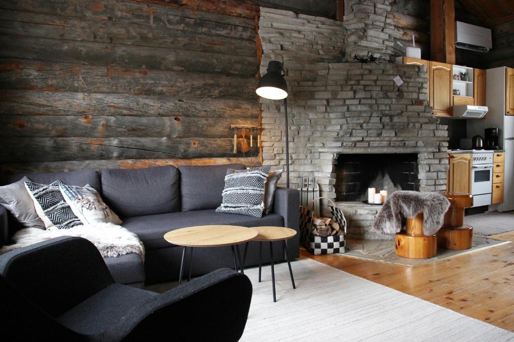 sala de estar con sofá y chimenea en Holiday Home Vonkamies, en Luosto