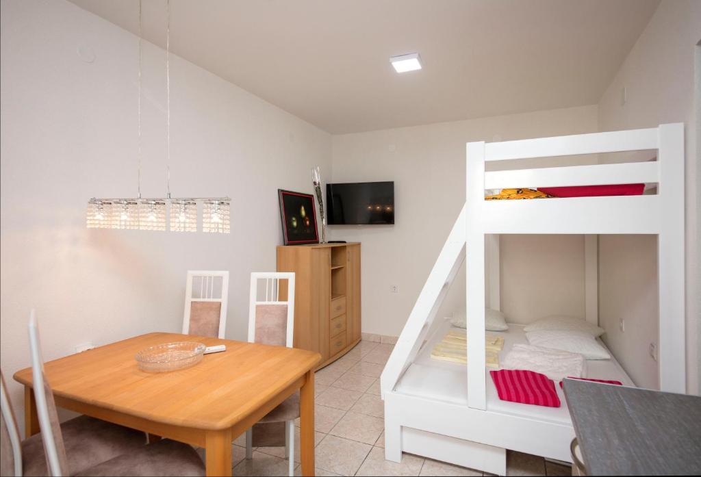 a room with a table and a bunk bed at Luxury Seafront flat Perzagno 3 in Prčanj
