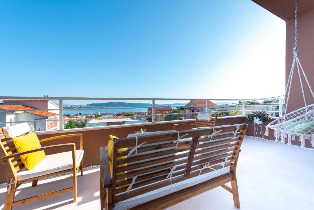 einen Balkon mit einer Bank und Meerblick in der Unterkunft Vecchia Donna in Kaštela