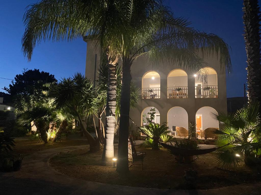 a building with a palm tree in front of it at Casamare San Giorgio 2 in Sciacca