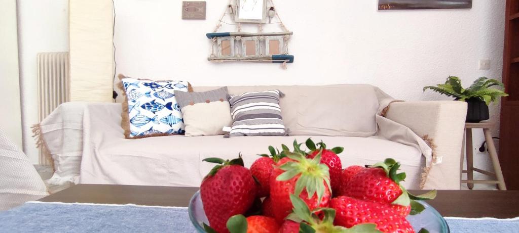 una sala de estar con fresas en un tazón sobre una mesa en Villa Βianca in Sithonia, en Gerakini