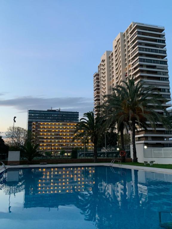 una piscina frente a algunos edificios altos en Playa de San Juan JULIA, en Alicante