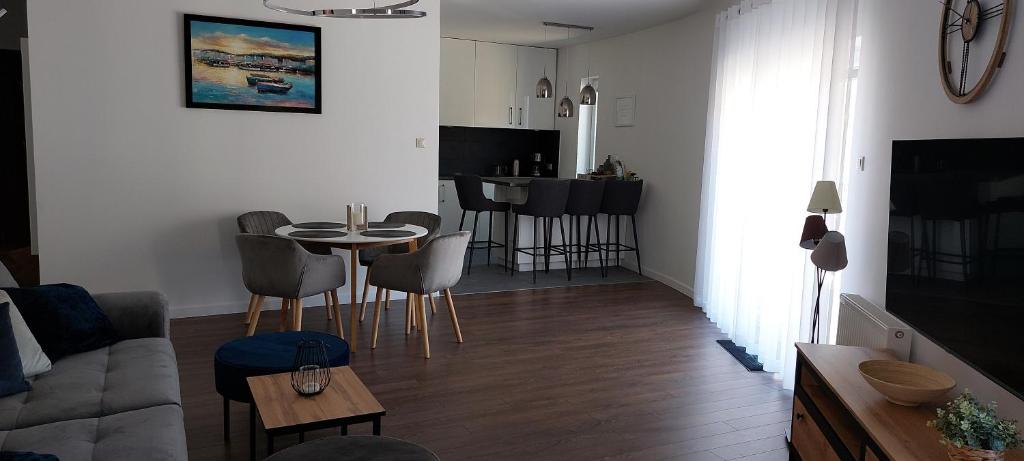 a living room with a couch and a table at Apartament Riva in Pobierowo
