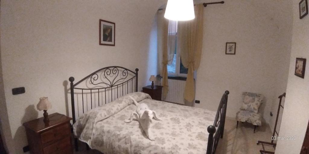 - une chambre avec un lit avec un animal rembourré dans l'établissement u' caruggiu de cisan, à Cisano sul Neva