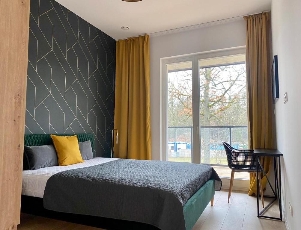 een slaapkamer met een bed en een groot raam bij Ostoja Białowieska in Hajnówka