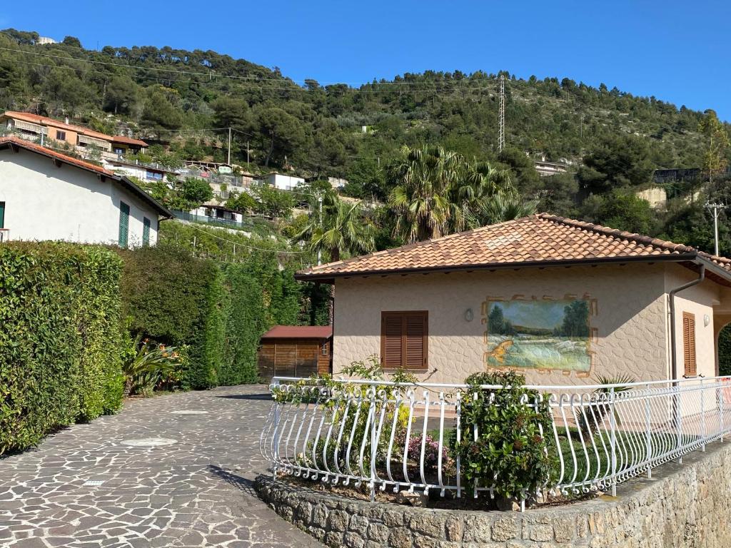 a house with a fence in front of a mountain at Pink House in Camporosso