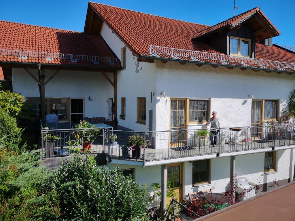 a woman standing on the balcony of a house at Haus Veronika in Wegscheid