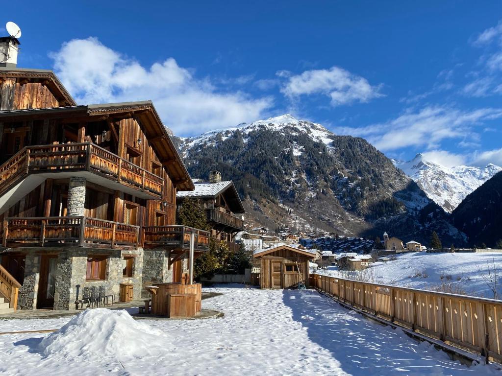 a lodge in the snow with mountains in the background at Chalet des Trappeurs Coeur Vanoise 16 persons in Champagny-en-Vanoise
