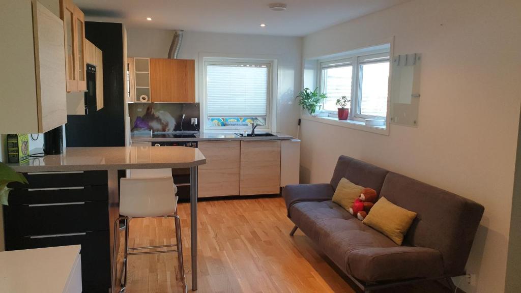 a living room with a couch and a kitchen at Modern basement apartments Stavanger, Sola airport, Kjerag, Preikestolen in Stavanger