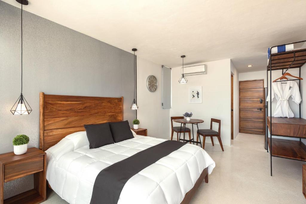 een slaapkamer met een groot wit bed en een tafel bij Boho Lofts & Studios in Playa del Carmen