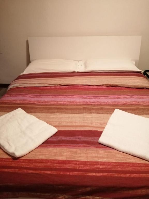 a pair of beds with white pillows on them at Golden Heart in Venice
