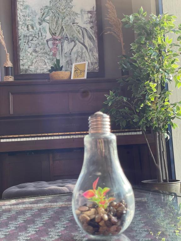 a glass bottle sitting on a table next to a piano at Auberge Oualidia Dream in Oualidia