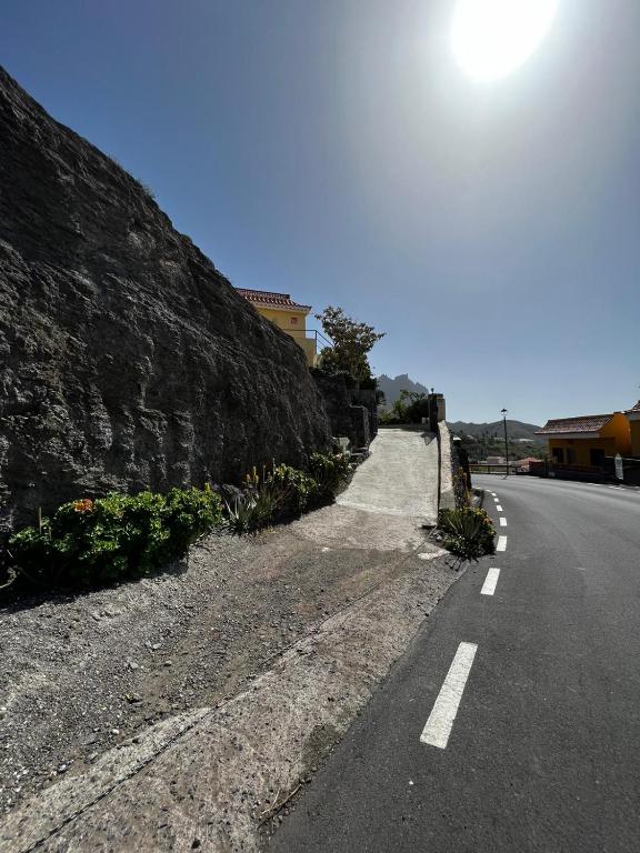 an empty road next to a stone wall at Casa Blanca in Alojera
