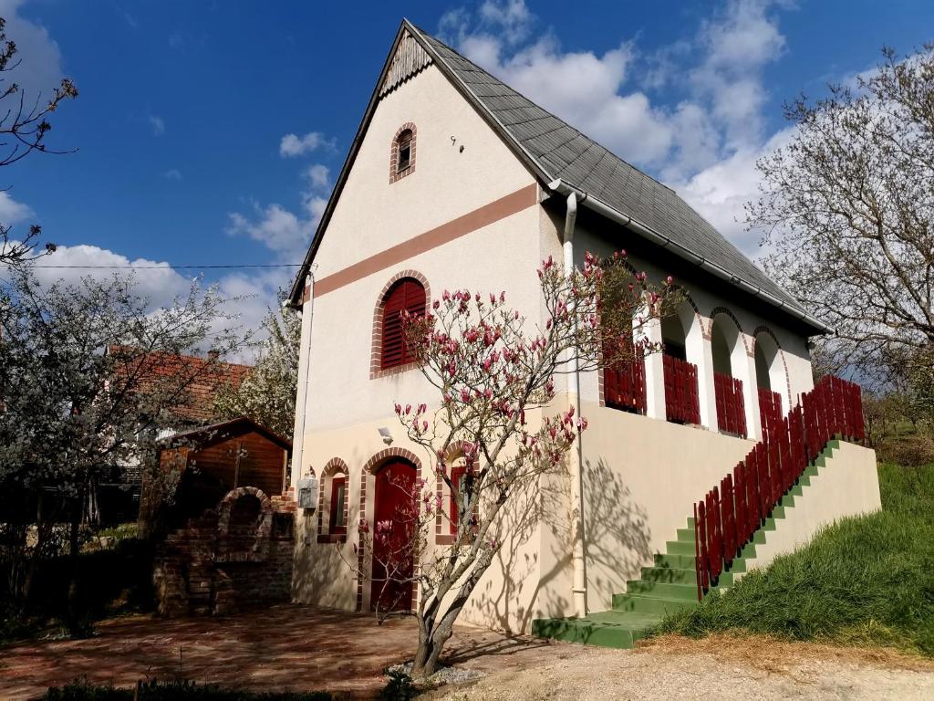 uma velha igreja branca com uma porta vermelha em pRezident Ház em Rezi