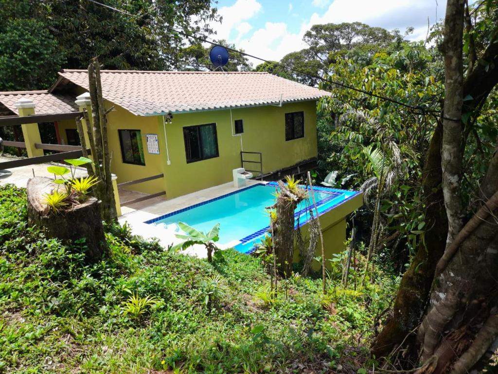 une maison jaune avec une piscine en face de celle-ci dans l'établissement Tu casa de campo, Menus de la Montaña, te espera, à Cerro Azul
