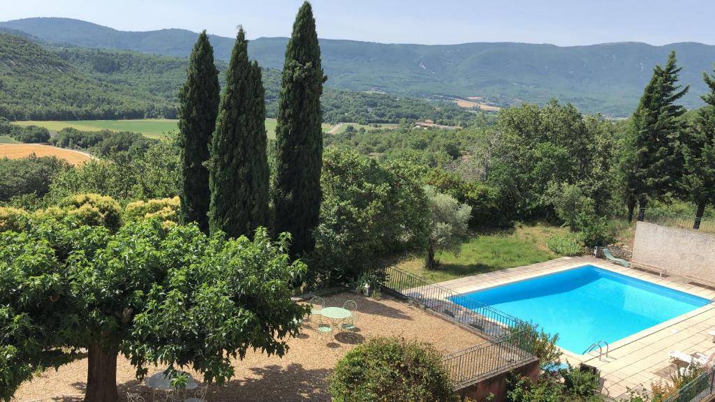 a villa with a swimming pool and trees at Appartement 3P Lubéron in Viens