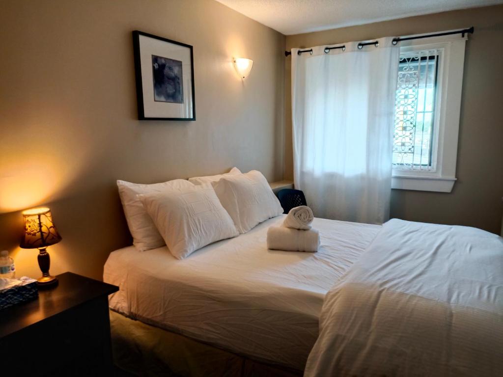 a bedroom with a large white bed with a window at Painted Turtle Guesthouse in Nanaimo