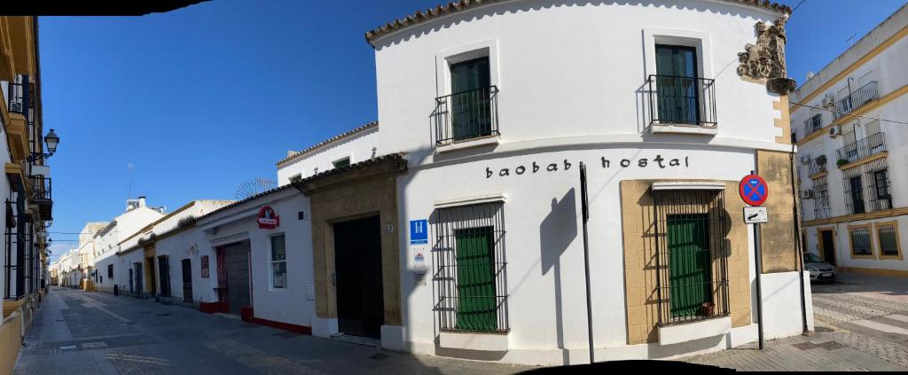 a white building on the side of a street at Baobab Hostal in El Puerto de Santa María