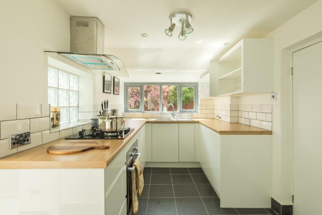 a kitchen with white cabinets and a counter top at Victorian House on London Road - Entire House, Central, Private Garden, Newly Renovated in King's Lynn