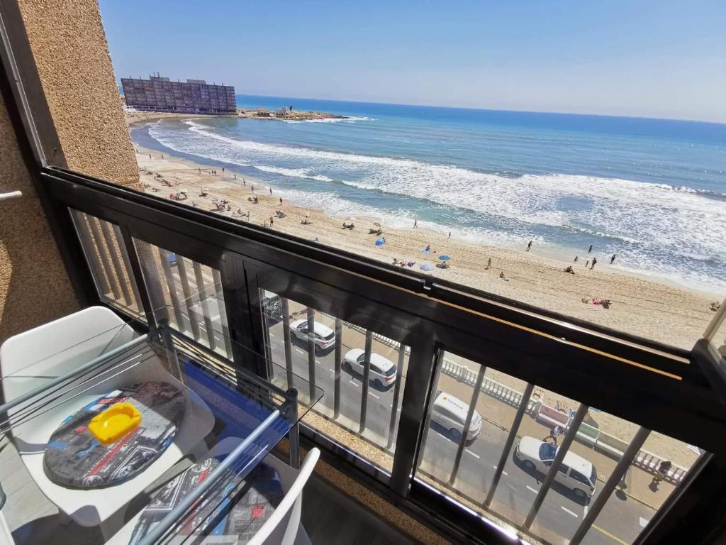 a balcony with a view of a beach and the ocean at Playa apartamento in Torrevieja