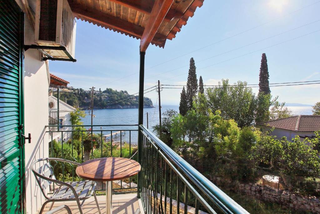 a balcony with a table and chairs and a view of the water at Zoulis Eleni in Kalami
