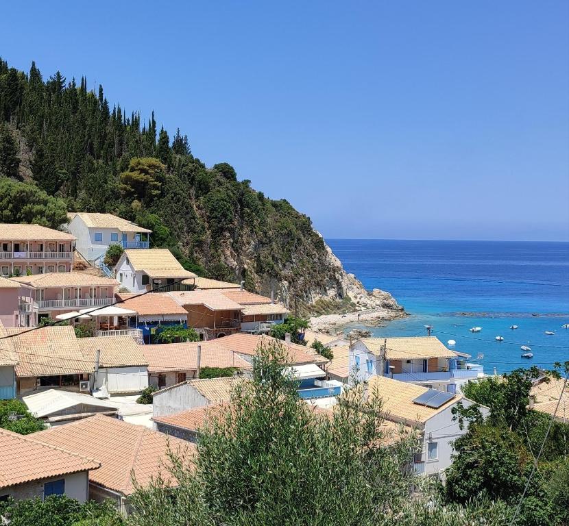 een groep huizen op een heuvel naast de oceaan bij Villa Spiros in Ayios Nikitas