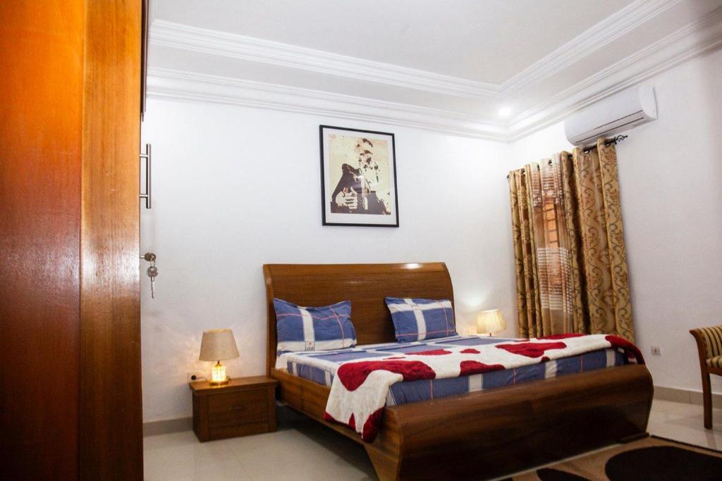 a bedroom with a bed with blue and red pillows at Mouna in Dakar