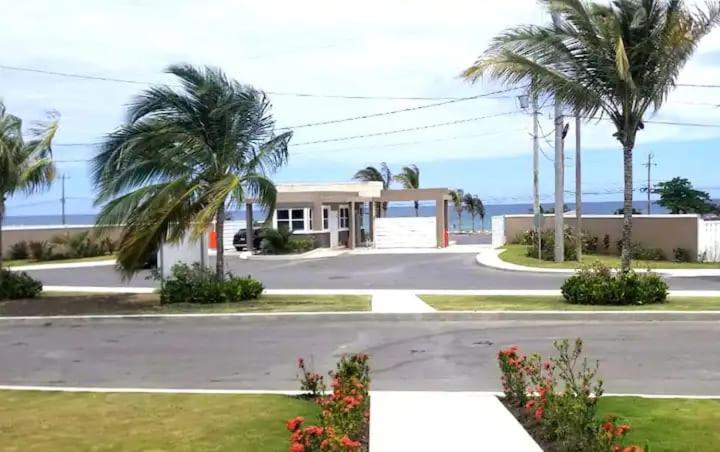 una casa con palmeras frente a una calle en Hamilton @ Oceanpointe a serene 2bed 2 bath Villa, en Lucea