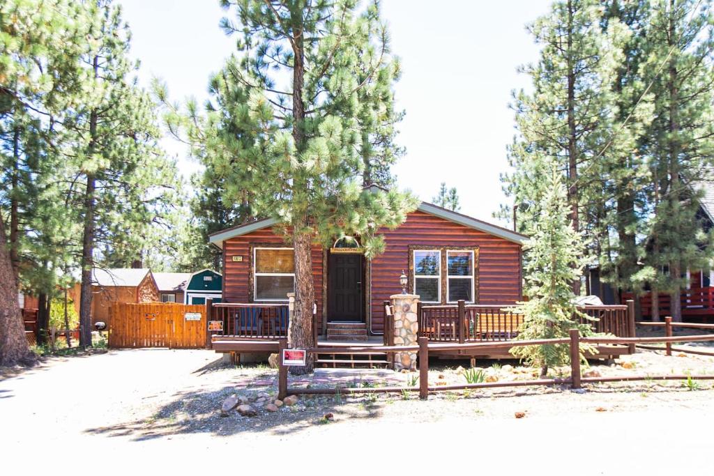 a log cabin with a porch and a fence at Whispering Pines - Big Bear Lake in Big Bear Lake