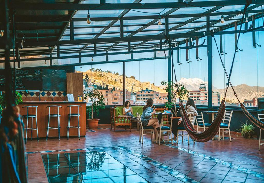 duas mulheres sentadas num restaurante com uma rede de descanso em The Rooftop Bolivia em La Paz