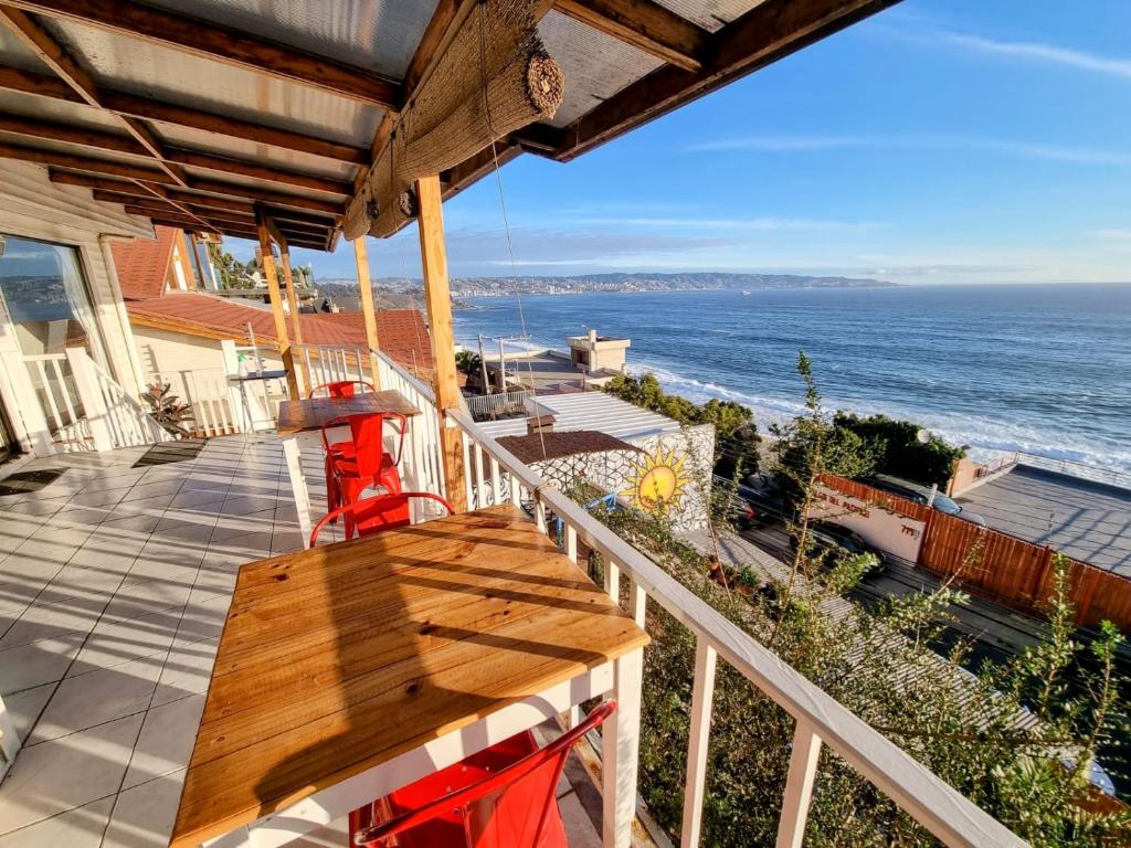 een houten tafel op een balkon met uitzicht op de oceaan bij Quinto Sol B&B in Viña del Mar