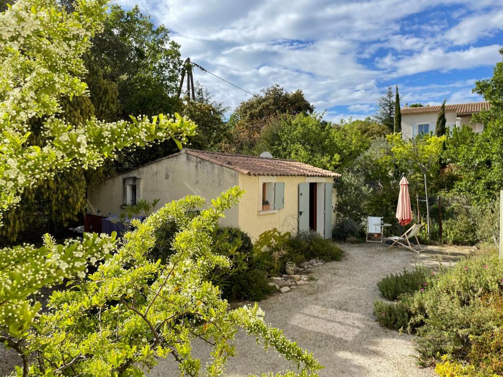 una pequeña casa en un jardín con sombrilla en Studio Ideal for guaranteed special moments - by feelluxuryholidays, en Cabrières-dʼAvignon