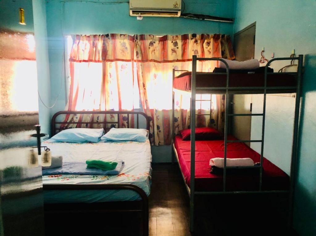 a bedroom with two bunk beds and a window at Greenleaf Guesthouse in Jerantut