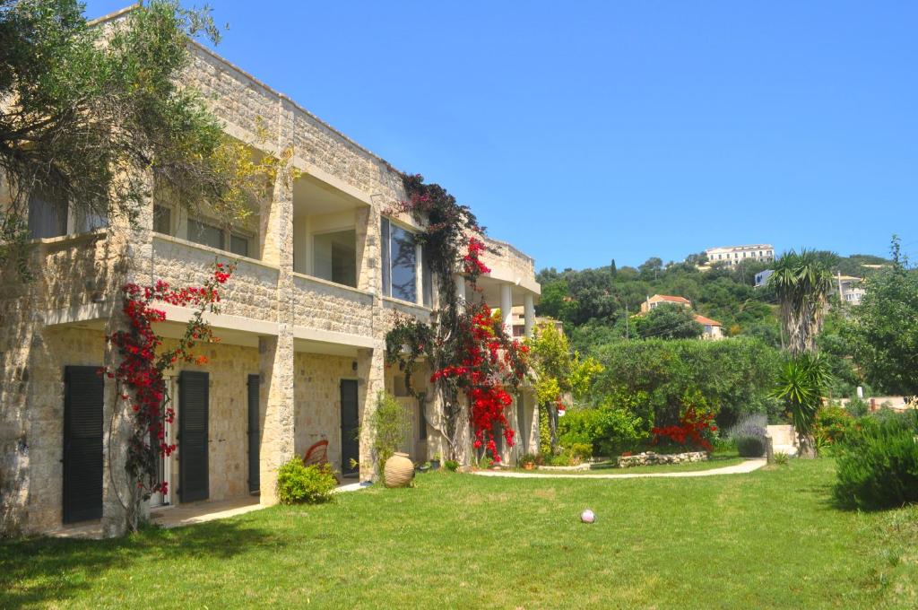 a house with flowers on the side of it at Haus Lemoni - Studio in Pelekas