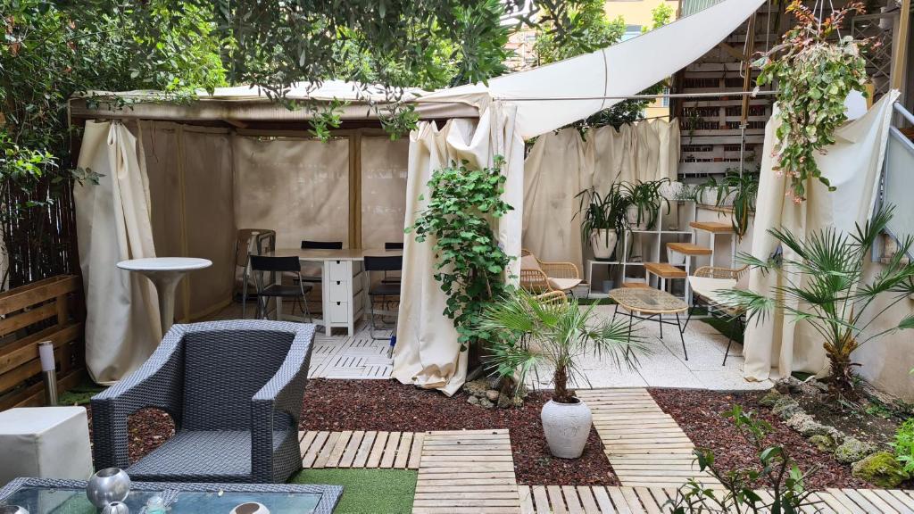 een patio met een tafel en stoelen en een tent bij Home Garden Rome Casa Kangen in Rome